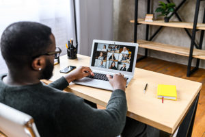 A guy talking online with employees via video call